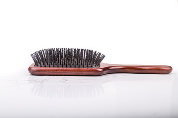 Comb with strand of hair on white background