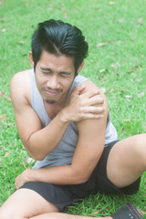 young sport man having shoulder pain in nature