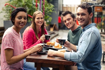Happy friends having coffee together at the bar