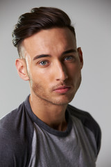 Obraz premium Vertical head and shoulders portrait of smiling young man