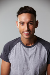 Fototapeta premium Vertical waist up studio portrait of smiling young man