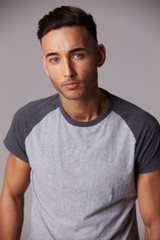 Obraz premium Vertical waist up studio portrait of serious young man