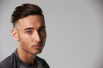 Head and shoulders studio portrait of smiling young man