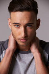 Obraz premium Vertical portrait of young man, holding his neck