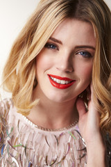 Glamorous blonde woman smiling to camera, vertical portrait