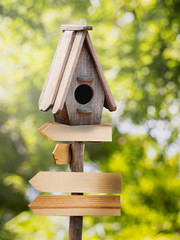 Wooden bird house on the wooden sign with a natural background.