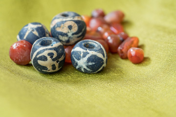 Ancient blue bird glass beads together with variety shapes of ancient carnelian beads on green silk cloth