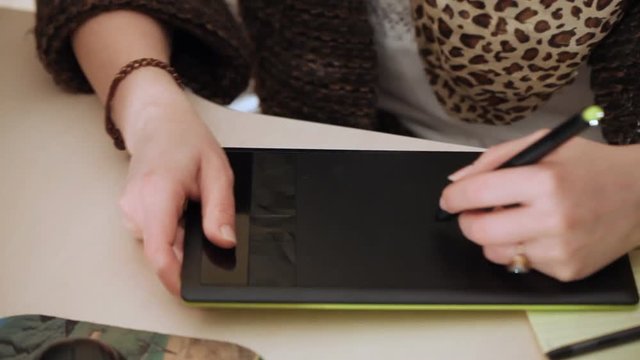 designer draws on graphic tablet close up