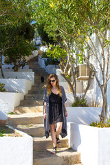 Attractive girl goes down the stairs in tropical, green surroundings