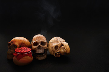 Still life of human skull and spell spirit pot on black background/Still life of human skull and spell spirit pot