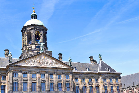 City hall or town hall of Amsterdam, the Netherlands. Historic building facade with bell tower and blue sky.