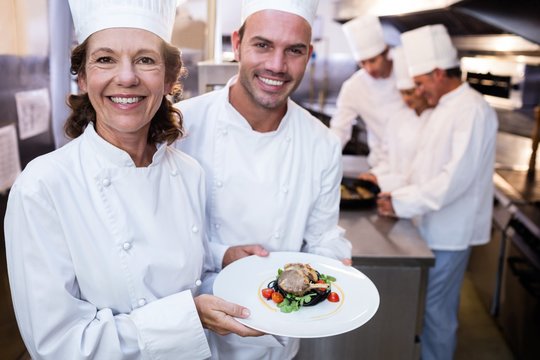 Two chefs presenting their dishes