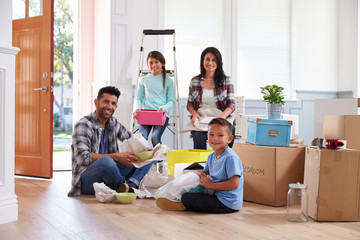 Portrait Of Hispanic Family Moving Into New Home