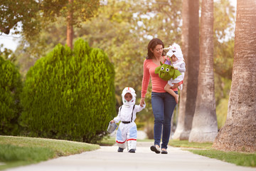 Parent Taking Children Trick Or Treating At Halloween