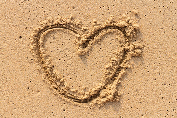 Heart handwritten on sand.