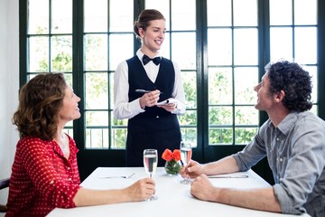 Young waitress taking an order from a couple