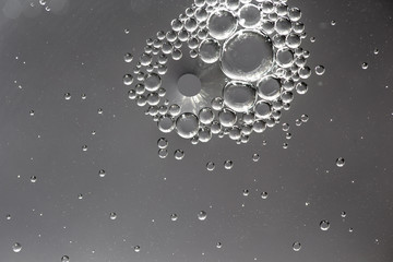 Oil drops in water on a gray background