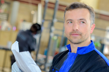 Closeup of workman holding paperwork