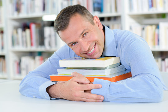 Middle aged man holding books