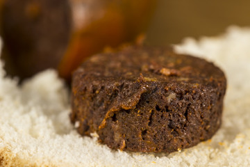 Detail of blood sausage slice over a piece of white bread