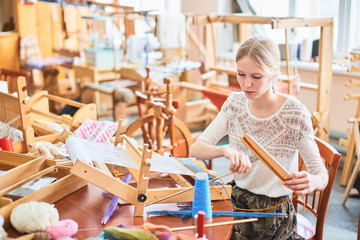 The girl in the production process of textiles are handmade on a loom