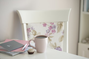 Напиток в розовой кружке и маленький десерт