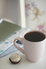 Напиток в розовой кружке и маленький десерт