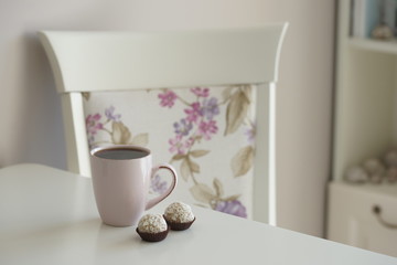 Напиток в розовой кружке и маленький десерт