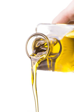 primo piano di olio di oliva che fluisce da oliera