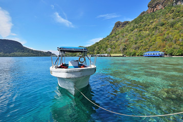 Fiber boat floating on a turquoise water in the Celebes sea.