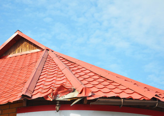  Close up on Broken Metal Roof and Rain Gutter.  Damaged Roof.