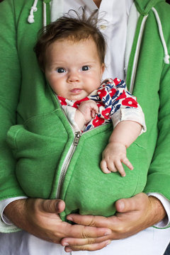 Father holding baby girl in zipped hoodie