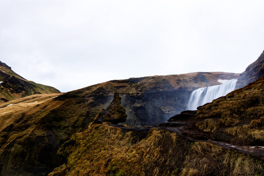 the famous troll rock overlooking Skogafoss waterfall in sout Iceland