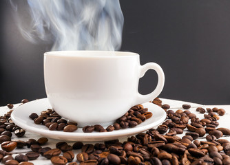 Hot coffee smoke and cofee beans on wood table