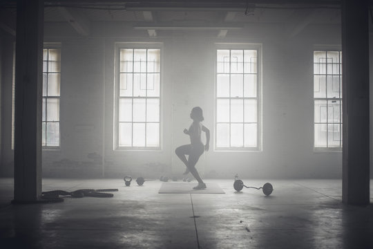 Black woman exercising in dark gym