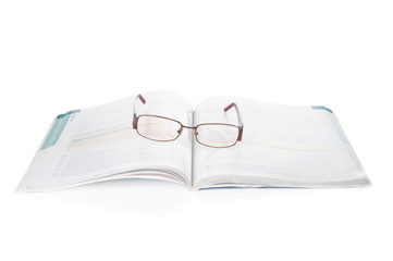 Textbook and eyeglasses on white background