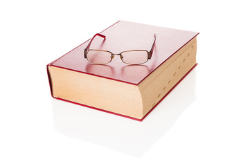 Big dictionary and eyeglasses closeup