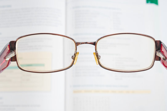 Eyeglasses and blurred textbook