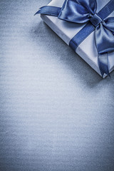 Gift box with bow on blue background holidays concept