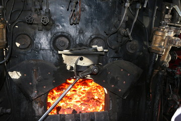 Open fire chamber of a very old steam locomotive with red-hot charcoal
