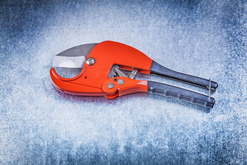 Pipe cutter on metallic background construction concept