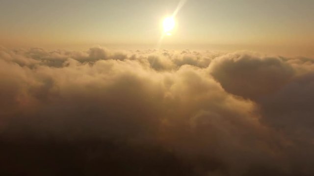 Flying through the cloudy sky golden sunrise