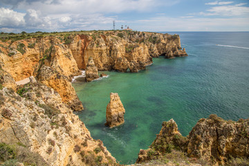 Fototapeta na wymiar Traumhafte leuchtende Felsen an der Algarve Küste mit menschenleeren Stränden und blühenden Landschaften