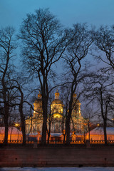 Fototapeta na wymiar St. Nicholas Naval Cathedral behind the trees illuminated at night, HDR, St. Petersburg, Russia