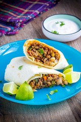 Mexican burrito with beef and vegetables wrapped in tortilla