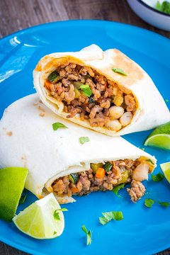 Mexican burrito with beef and vegetables wrapped in tortilla
