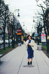 beautiful girl walking down the street. The wind lifted her hair up.