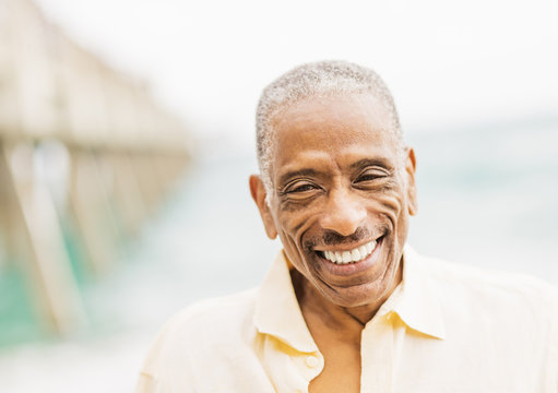 Older mixed race man smiling on beach