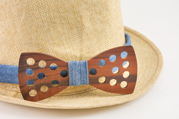 Wooden bow tie around a hat.
