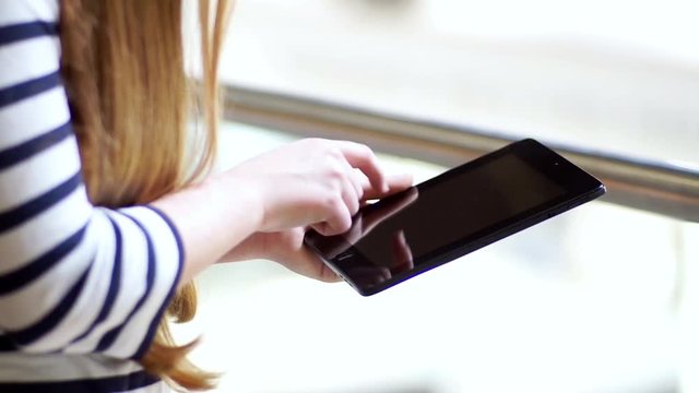 Junge Studentin tippt auf Tablet im Freifunk
